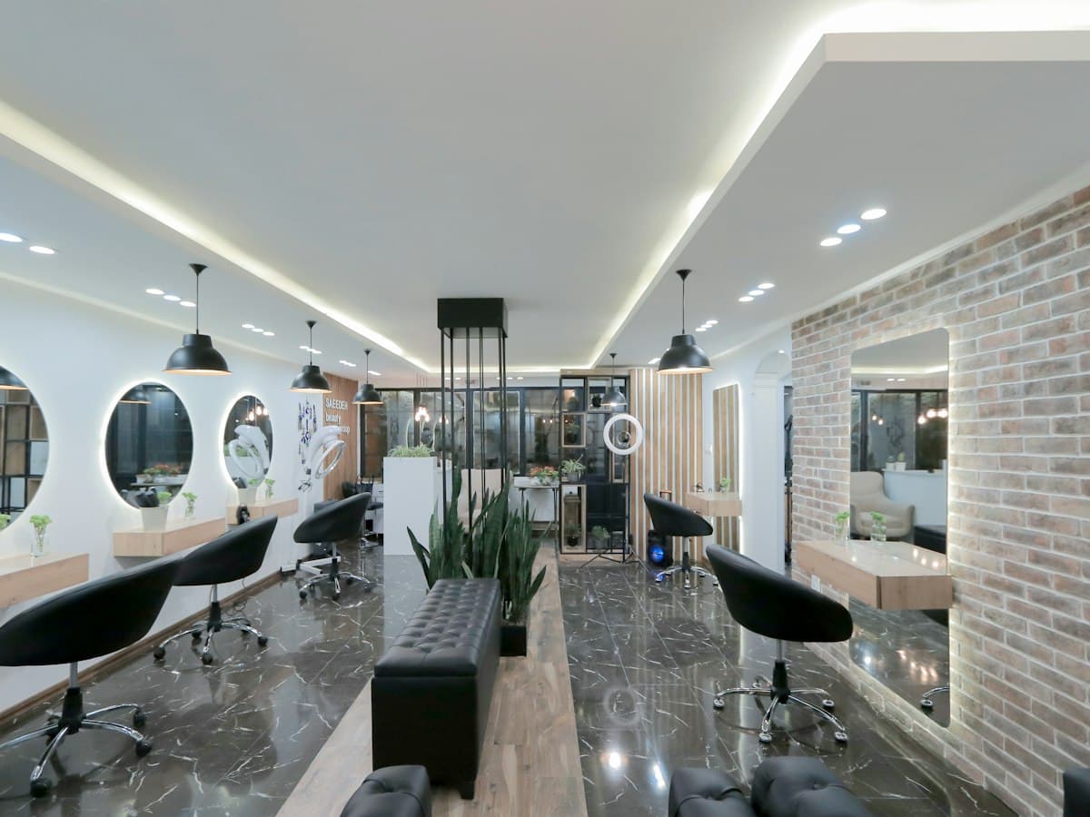 A modern salon with a row of styling stations and round mirrors